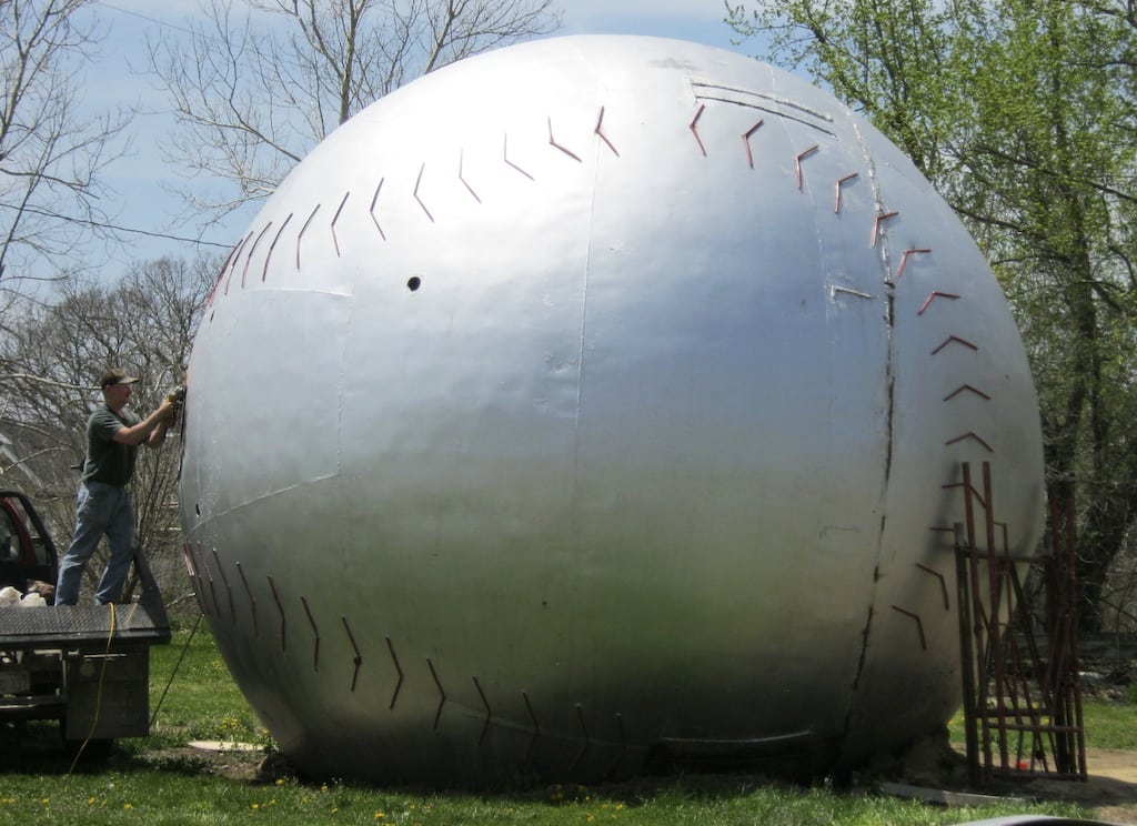 Keith Wilson does welding work on a water tower top being turned into a giant baseball in Muscotah, Kansas, April 30, 2013.  