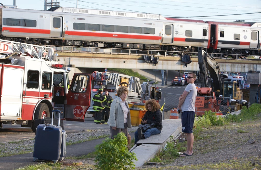 Passengers wait to be picked-up after two commuter trains collided in Bridgeport, Connecticut, causing one to derail and injuring up to 70 passengers, May 17, 2013. 