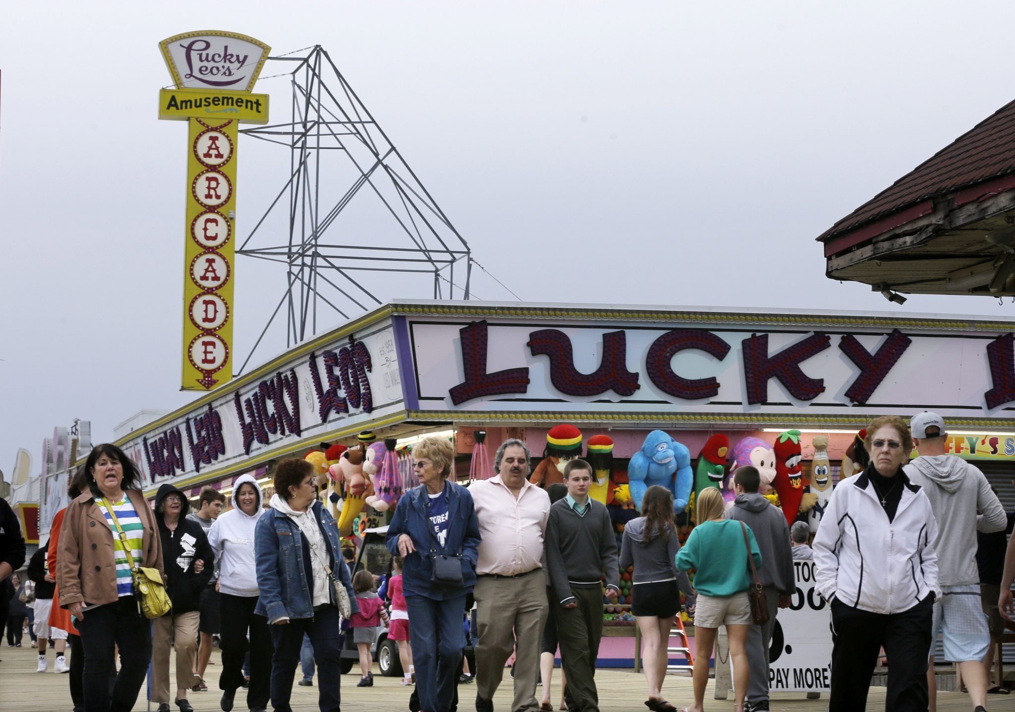 People walk past open attractions along the newly rebuilt boardwalk in Seaside Heights, N.J., Saturday, May 18, 2013. 