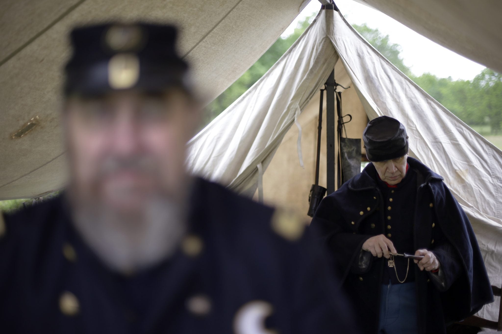 In this Friday, May 24, 2013 photo, Richard Baldino, right, accompanied by Dave Morris, both portraying army surgeons with the 2nd Division 11th Corps Army of Potomac, cleans out his pipe at the George Spangler Farm that served as a field hospital during the Civil War, in Gettysburg, Pa. 