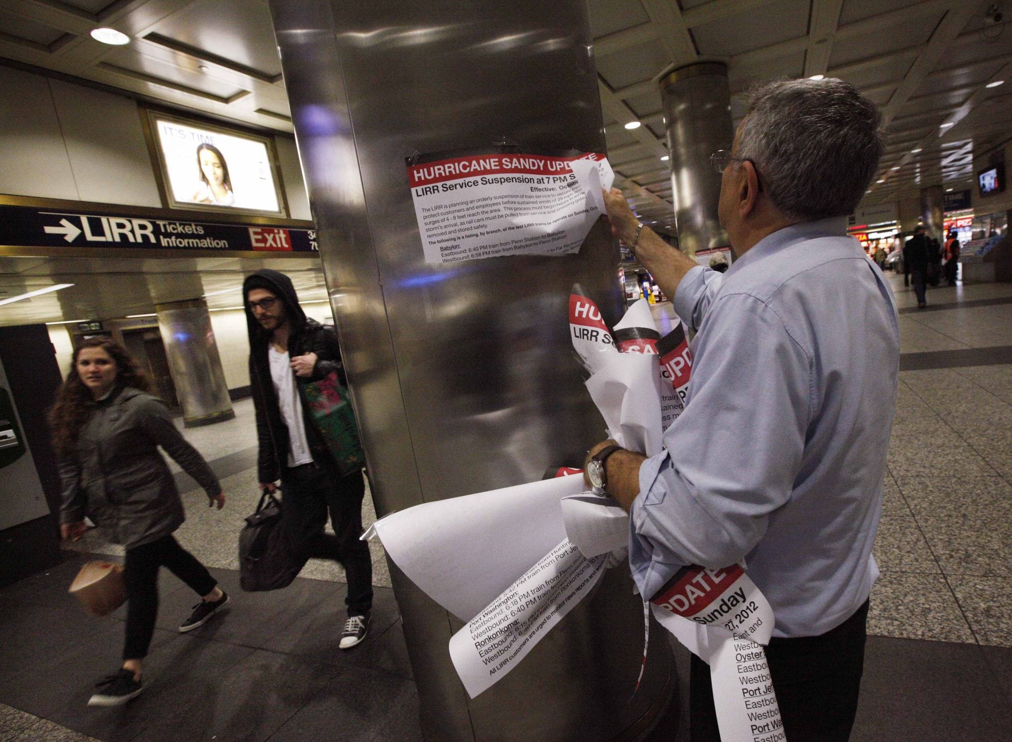A station agent removing signs inside Penn Station. 