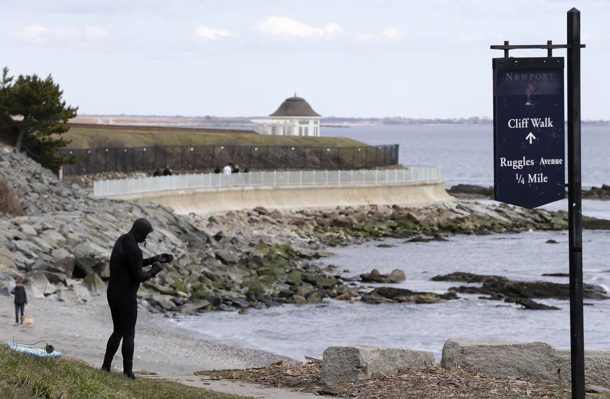 In this Wednesday, March 27, 2013 file photo Dave Livingston, left, removes his gloves while standing near a portion of the Cliff Walk, in Newport, R.I. Large portions of the Cliff Walk damaged by Superstorm Sandy has yet to be repaired as the summer tourist season approaches. 