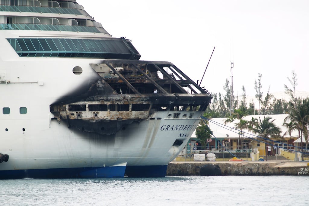 The fire-damaged exterior of Royal Caribbean's Grandeur of the Seas cruise ship is seen while docked in Freeport, Grand Bahama island, Monday, May 27, 2013. Royal Caribbean said the fire occurred early Monday while on route from Baltimore to the Bahamas on the mooring area of deck 3 and was quickly extinguished. All 2,224 guests and 796 crew were safe and accounted for. 