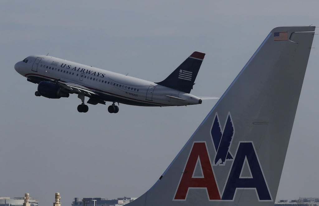 A U.S. Airways jet departs Washington's Reagan National Airport next to an American Airlines jet outside Washington, February 25, 2013.  