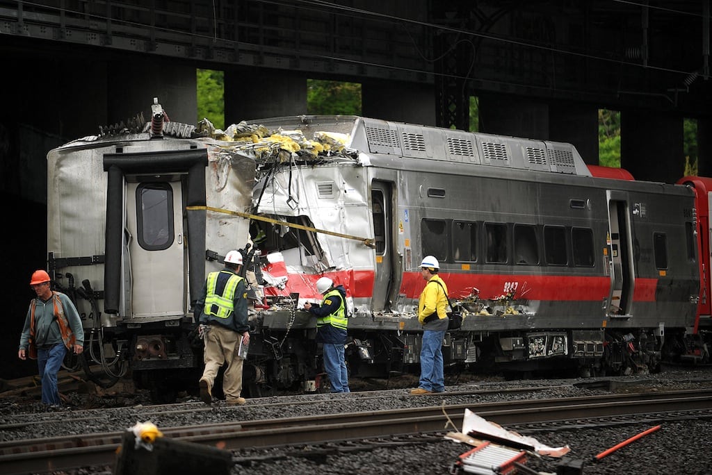 Metro-North employees work at the site of Friday's train crash in Bridgeport, Connecticut. Crews will spend days rebuilding 2,000 feet of track, overhead wires and signals following the collision between two trains Friday evening that injured 72 people, Metro-North President Howard Permut said Sunday.  