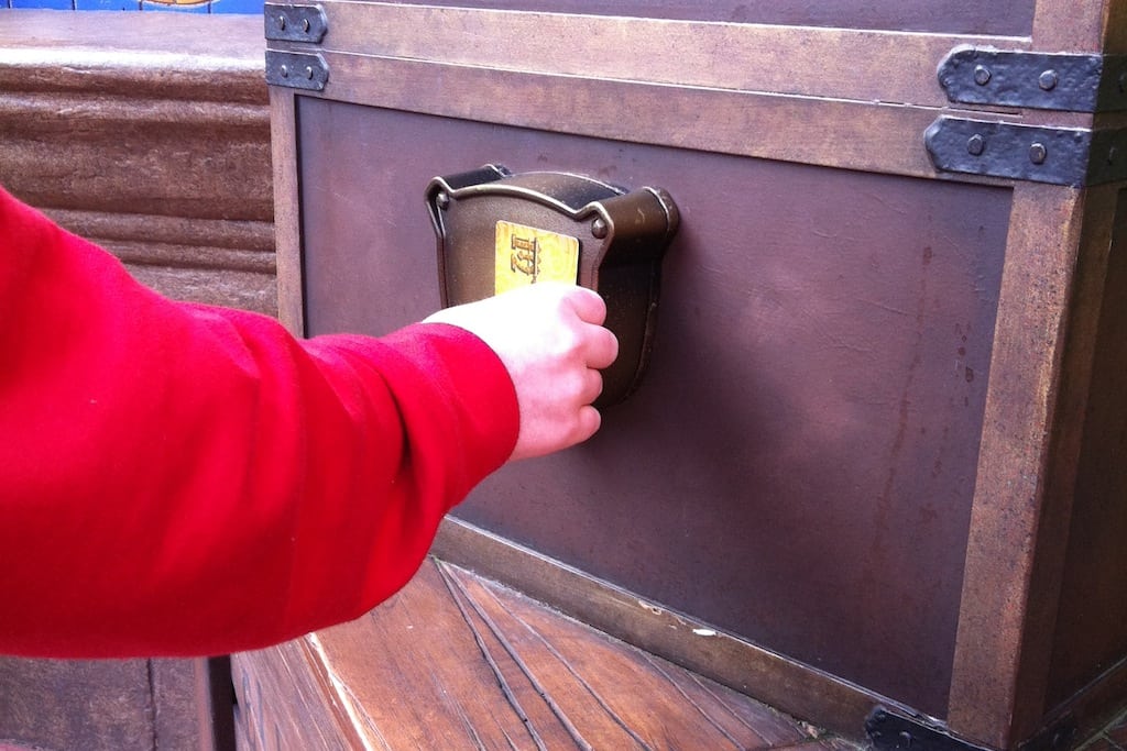 In this Feb. 15, 2013 photo, a Walt Disney World guest swipes his key card while playing the "Sorcerers of the Magic Kingdom" game at the Magic Kingdom theme park in Lake Buena Vista, Fla. 