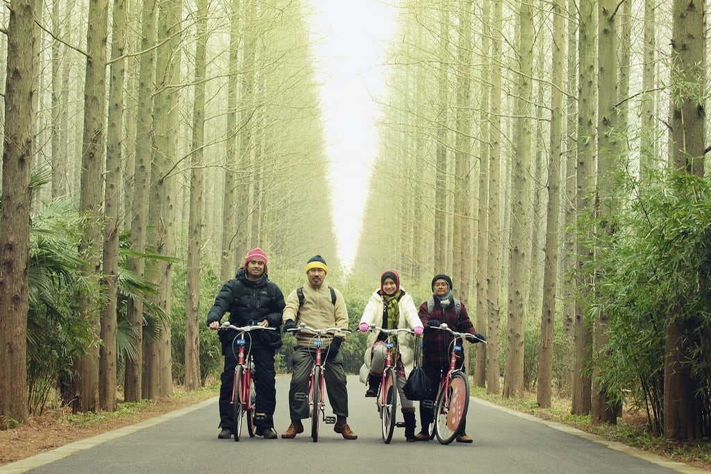 A family takes a bike ride through Dongping National Forest Park as part of a vacation to Shanghai. 