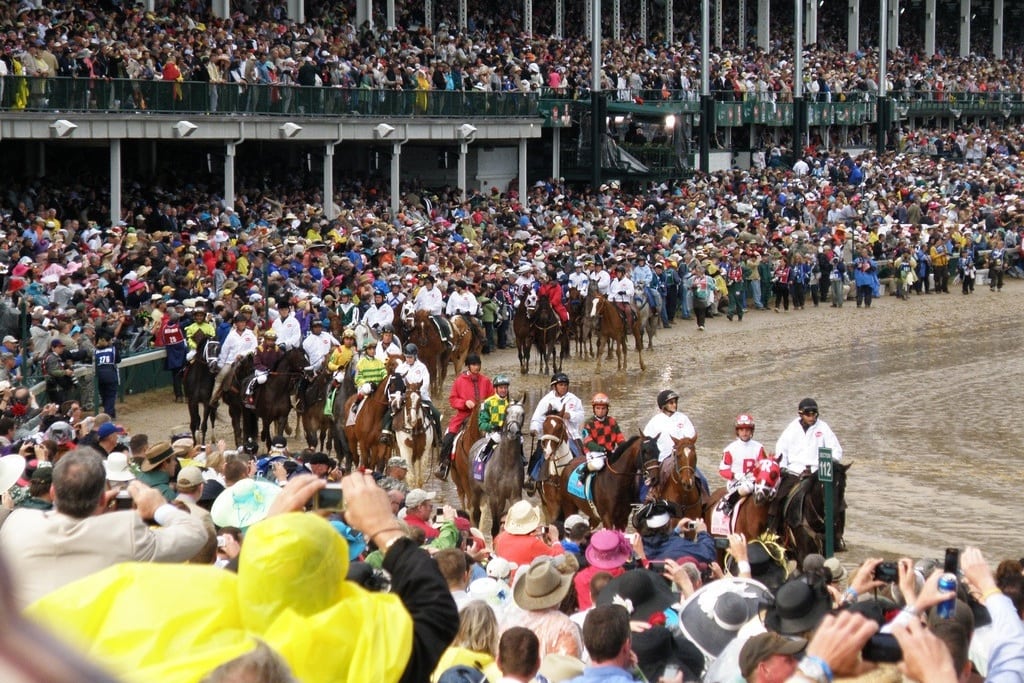 Visitors cheer on the horses and jockeys at the Kentucky Derby. 