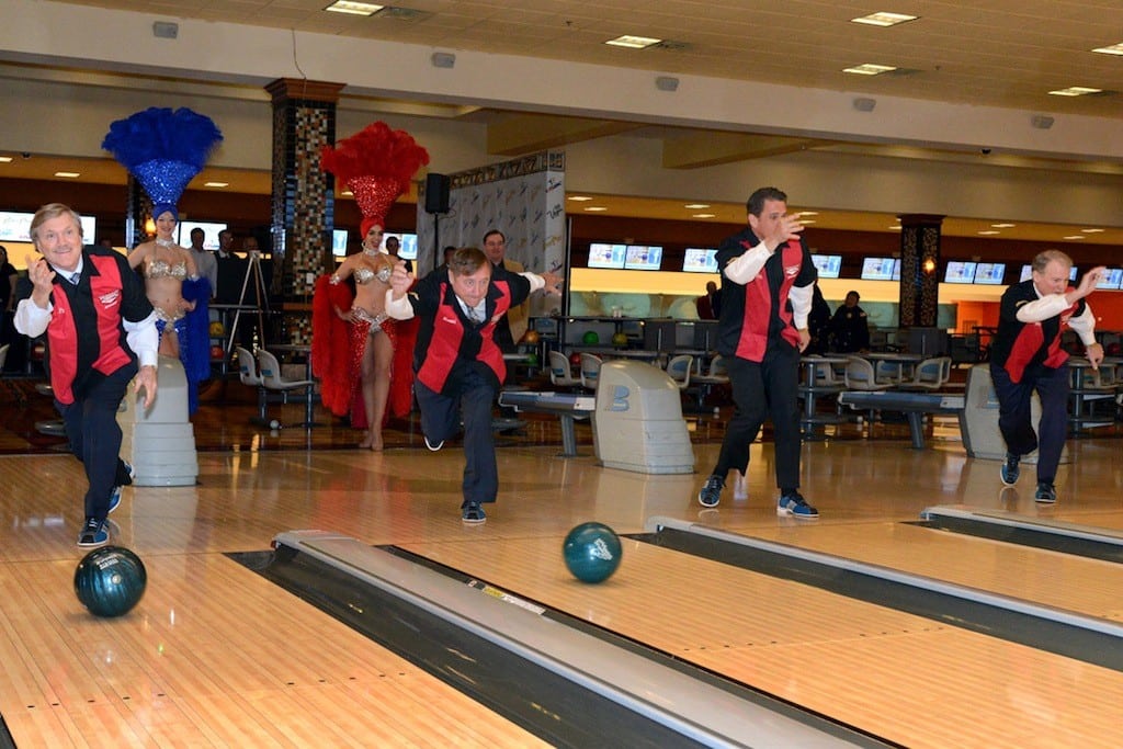In this photo provided by the Las Vegas News Bureau, Las Vegas representatives throw ceremonial bowling balls in celebration of an announcement Tuesday, April 30, 2013. 