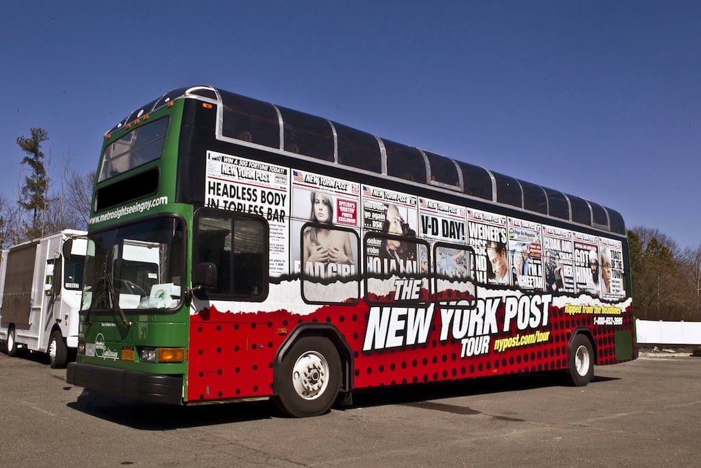 The New York Post tour bus is covered is scandalous headlines.