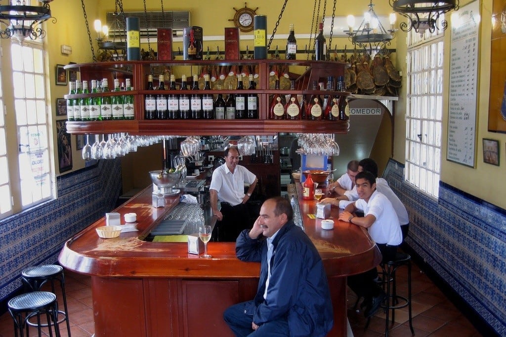 Spanish waiters hang around an empty tapas bar in Sevilla, Spain. 