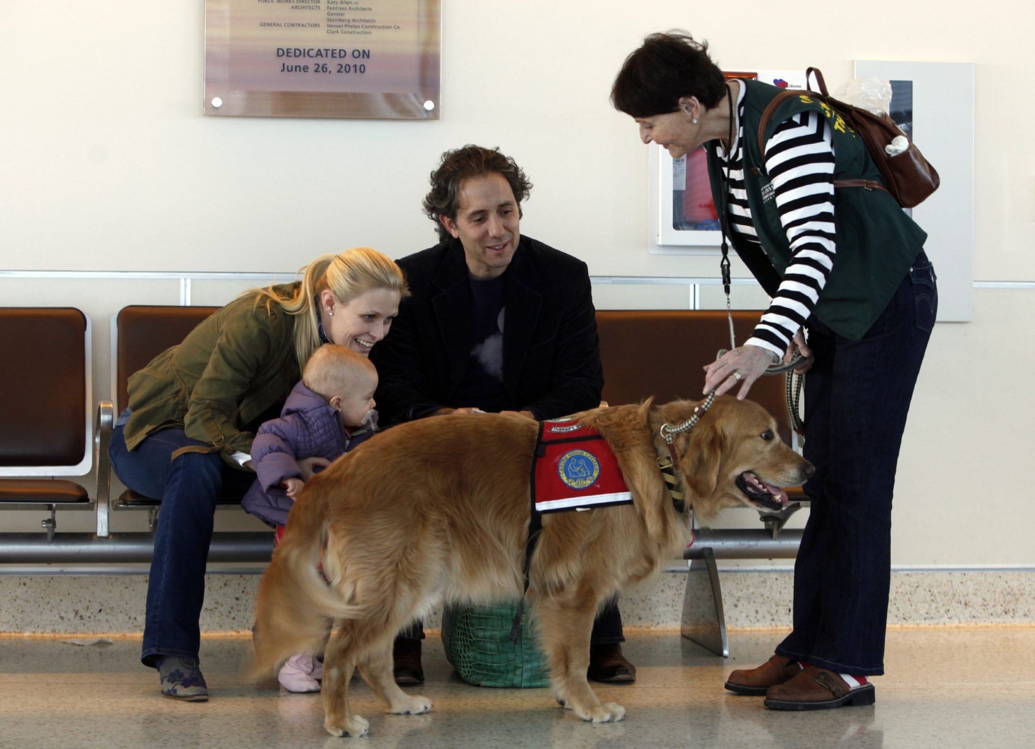 Kyra Hubis and her "therapy dog" Henry James stop to visit Nelson and Charlotte Hill and their 15-month-old daughter at Mineta San Jose International Airport in San Jose, California, on January 28, 2013. The duo roam the airport terminals looking for anyone who needs relief from fears of flying or other stresses. 