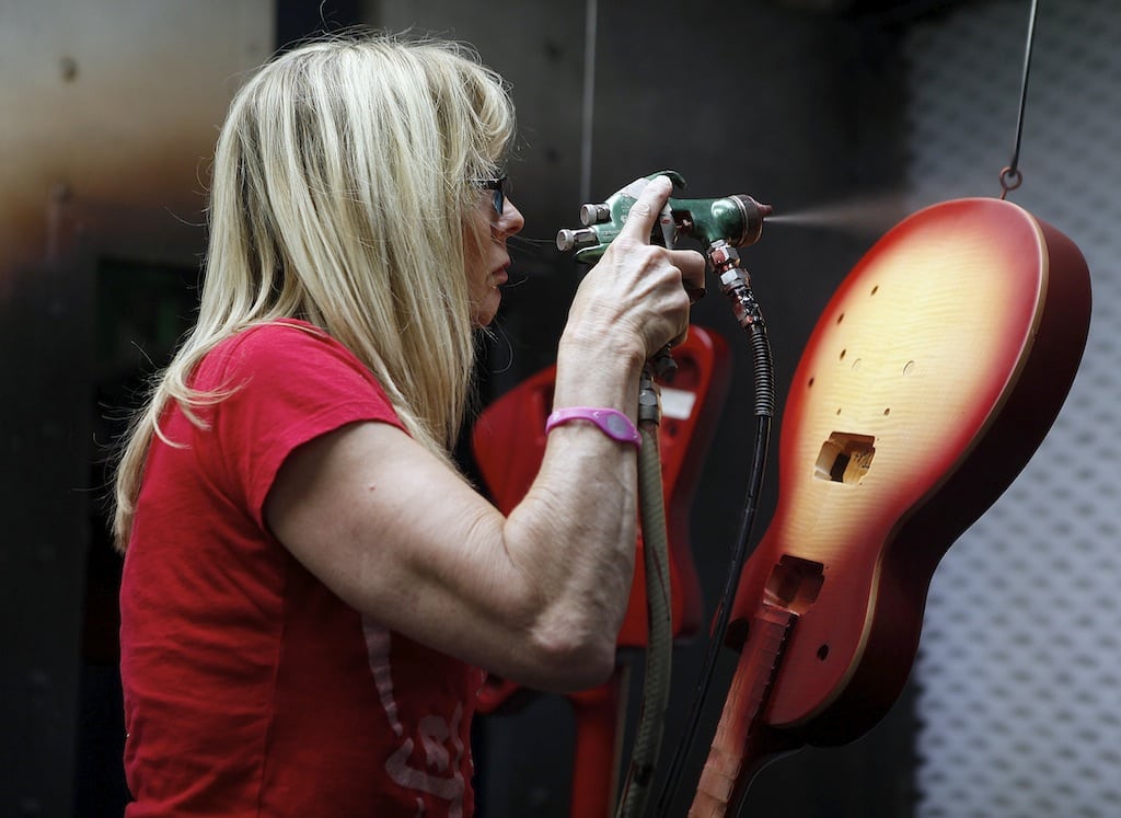 An employee custom paints a guitar in the paint shop at the Gibson USA solid-body guitar factory in Nashville, Tennessee, September 22, 2011. A month prior, armed federal agents swooped into the corporate offices and Nashville factory of Gibson guitar after contraband ebony and rosewood they suspected was illegally imported from India. 