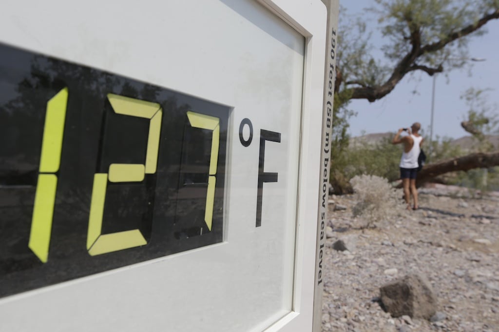 A visitor to the Furnace Creek Vistitor Center walks by a digital thermometer in Death Vally National Park Friday, June 28, 2013 in Furnace Creek, Calif. Excessive heat warnings will continue for much of the Desert Southwest as building high pressure triggers major warming in eastern California, Nevada, and Arizona.