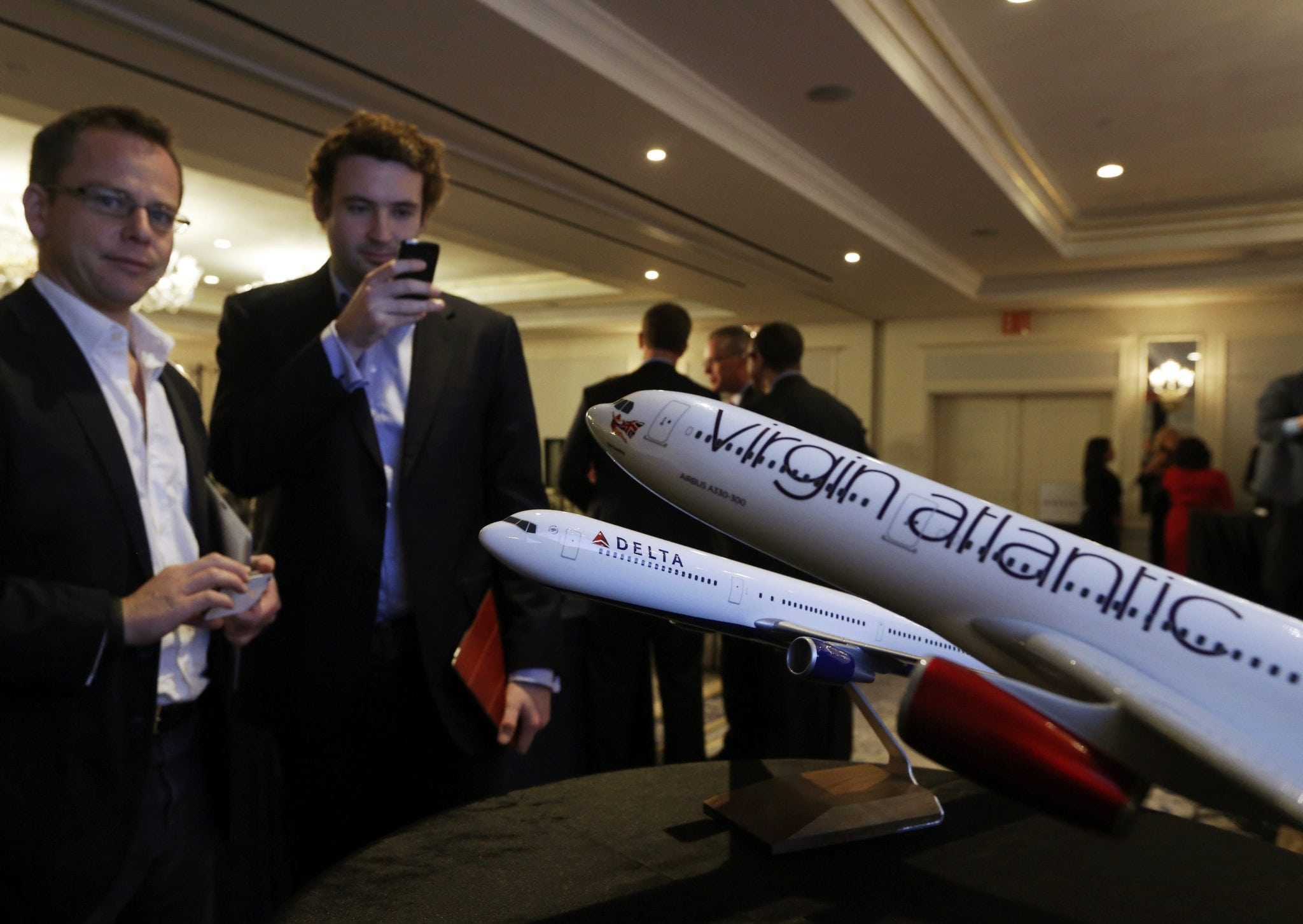 Attendees take pictures following a news conference announcing a sale of Virgin Atlantic airline to Delta Air Lines, in New York. 