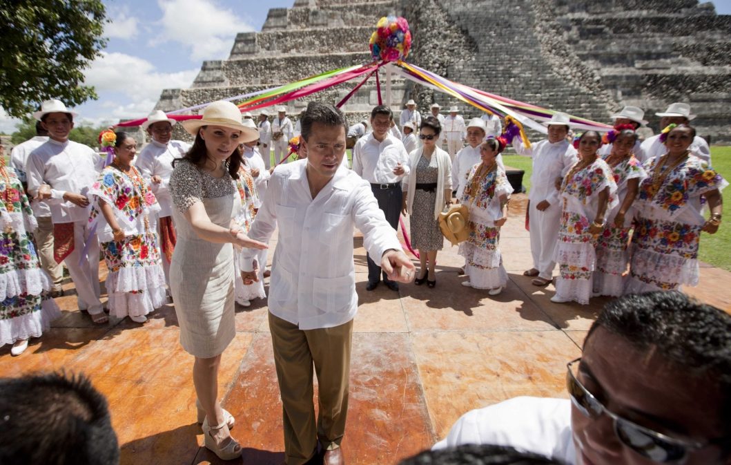 Mexico's President Enrique Pena and his wife Angelica Rivera instruct their security detail to allow access to China's presidential photographer, as they prepare for a group photo with Chinese President Xi Jinping, and his wife Peng Liyuan, near the Mayan ruins of Chichen Itza, southern Mexico, Thursday, June 6, 2013. 