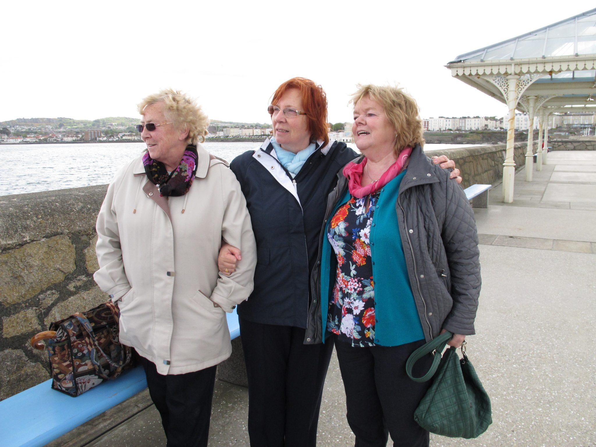 In this May 13, 2013 photo, Marie Theresa Gill, center, poses with her friends Kathleen Greenhough, right, and Mary Murray at the pier in Dun Laoghaire in Dublin Co., after a wreath-laying ceremony to honor the so-called "Forgotten Irish" the thousands of young Irish who emigrated to Britain during the 1950s and 1960s. 