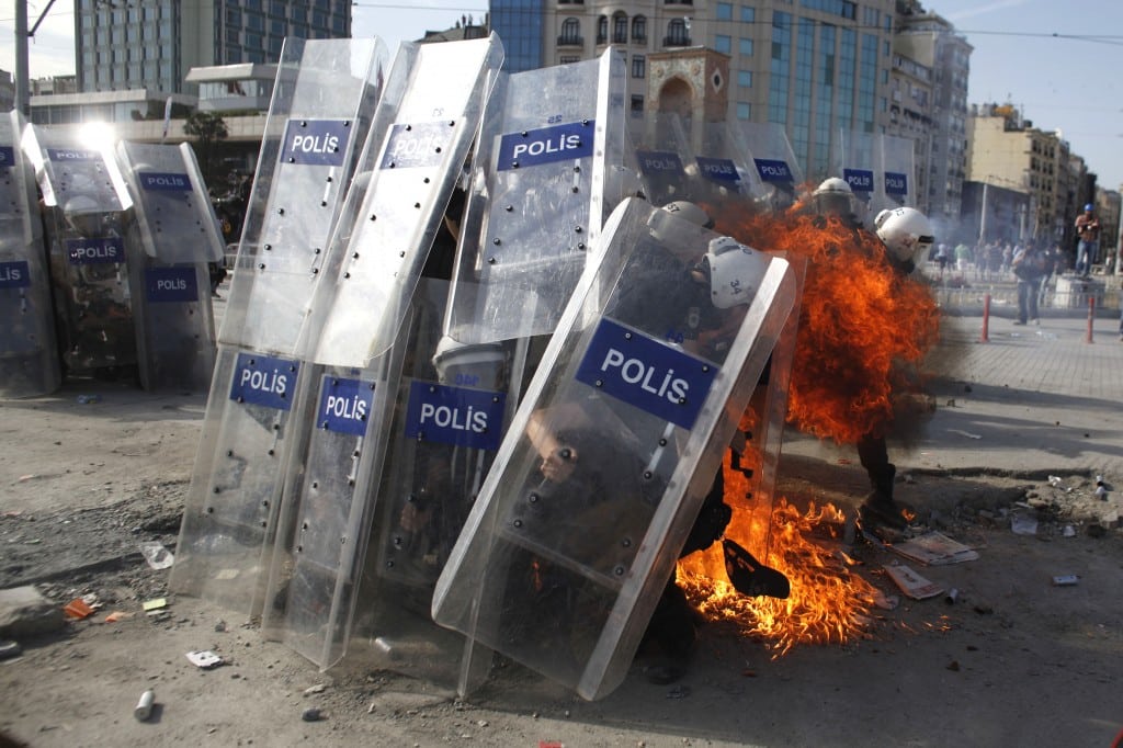 Police move past barricades in Istanbul square. 