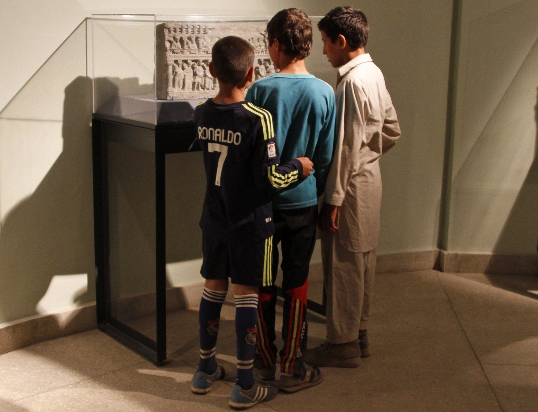 Afghan youth look at an artifact at the National Museum in Kabul, Afghanistan, Friday, June, 28, 2013. 