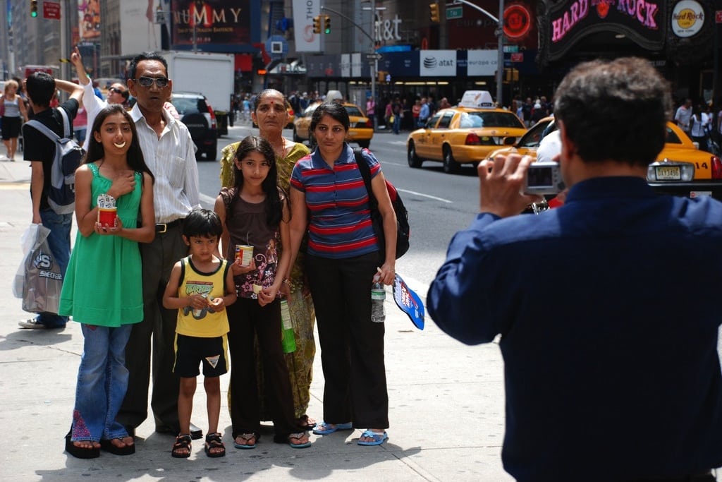 Tourists stop to take a family photo in the middle of Times Square. 