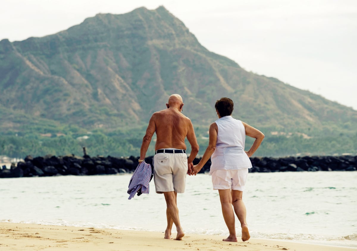 Not-Chinese tourists, walking on Duke Kahanamoku Beach in Hawaii.