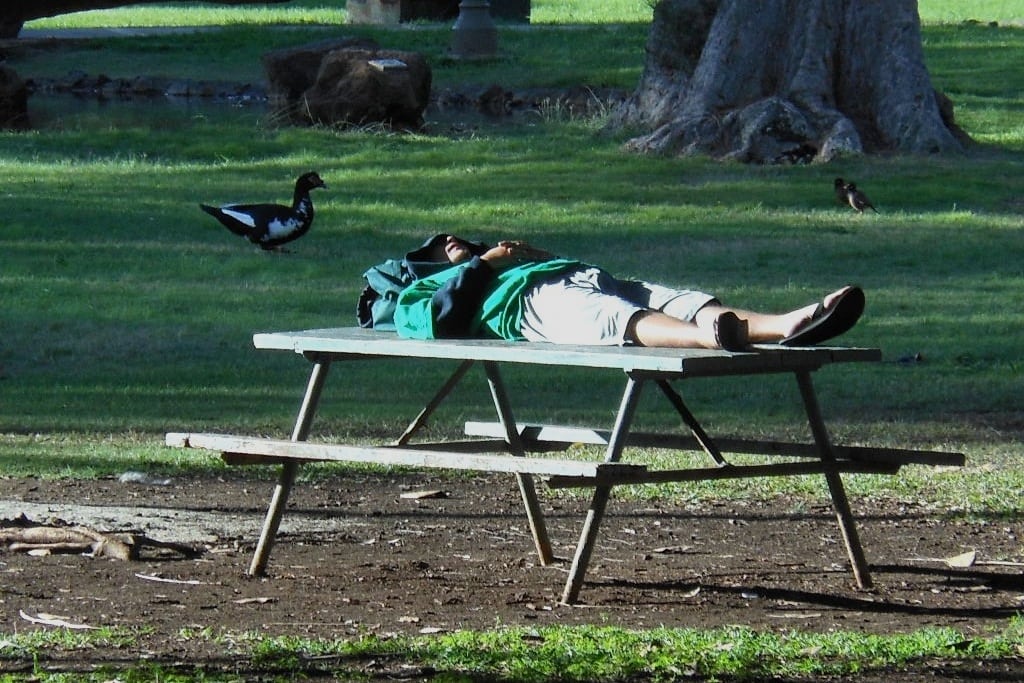 A homeless man sleeps on a park table in Honolulu, Hawaii. 