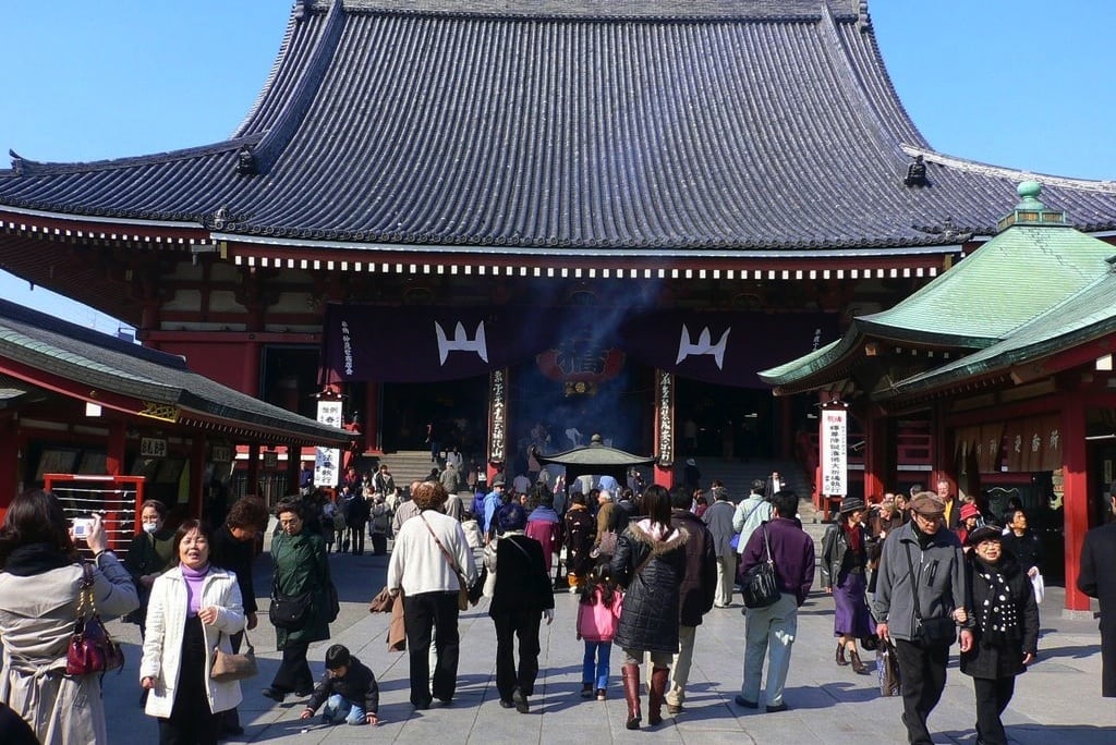 Tourists walk through the Asakusa budhist temple in Japan. 