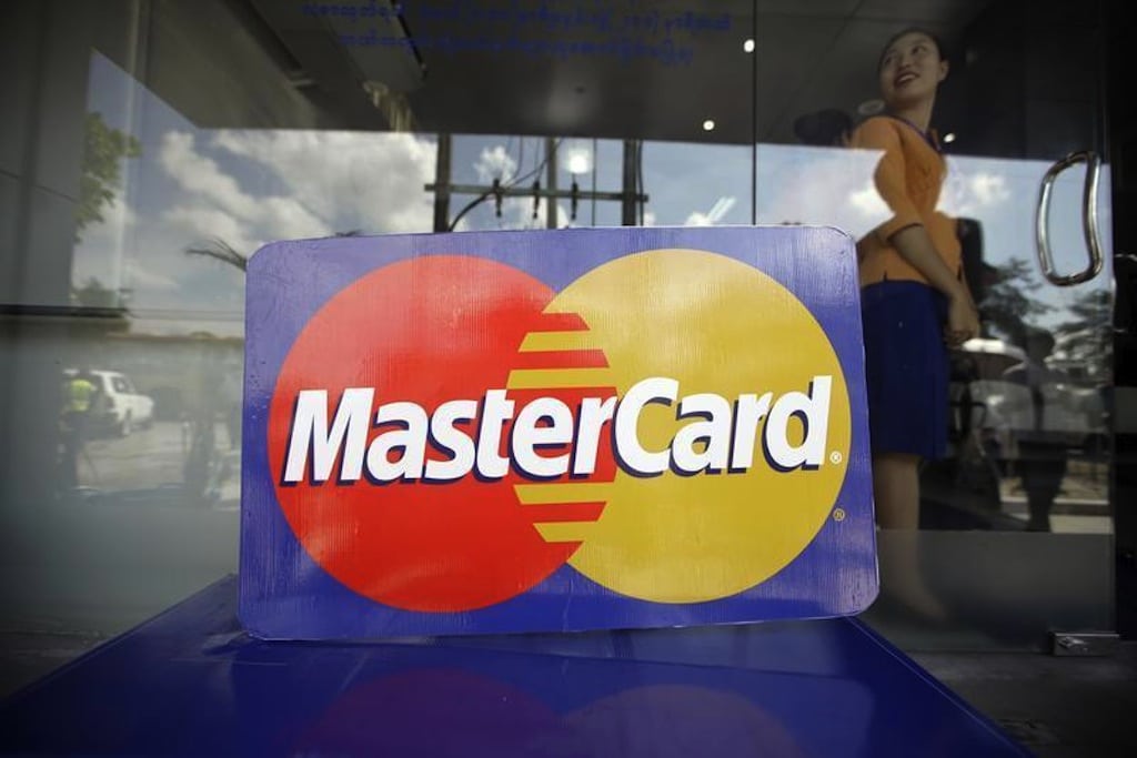 An employee stands behind a MasterCard logo during the launch of the international credit card issuer's first ATM transaction in Myanmar, in Yangon November 15, 2012. 