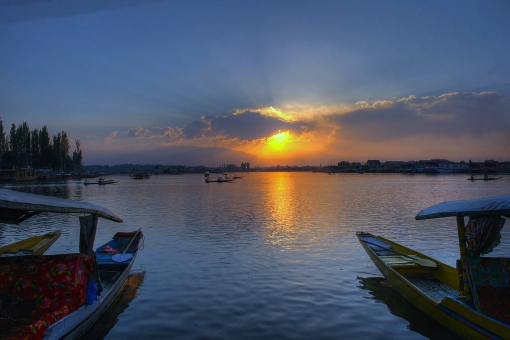 The sun sets behind the small boats known as 'shikara' sit on Dal Lake, Kashmir.