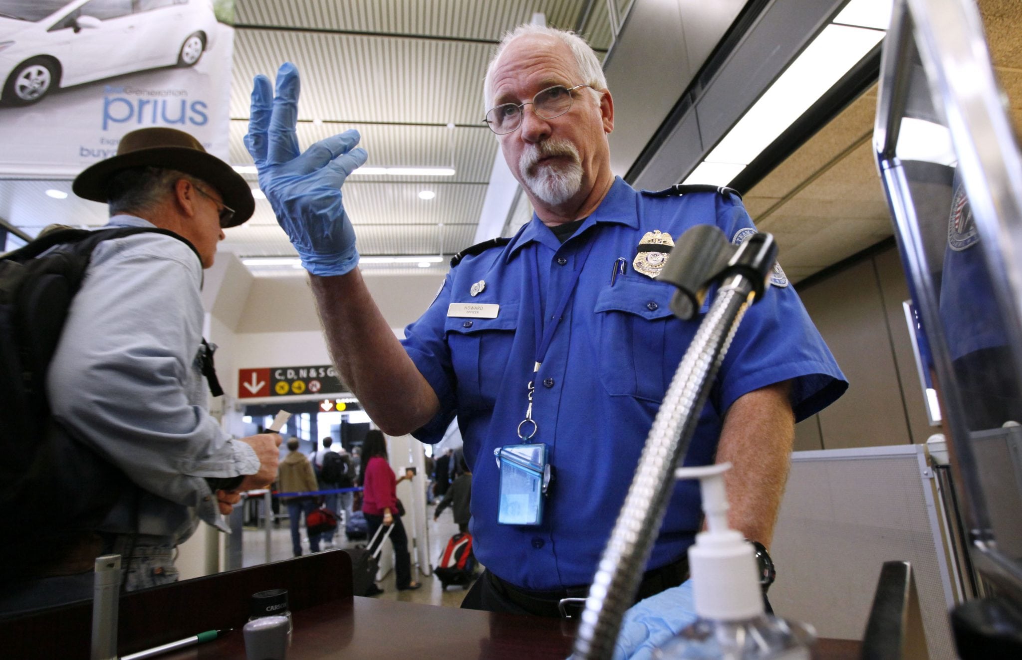 The TSA published a video to educate LGBTQ travelers, but still doesn't seem to understand non-binary gender identity. In this Jan. 4, 2010 file photo, TSA officer Robert Howard signals an airline passenger forward at a security check-point at Seattle-Tacoma International Airport in SeaTac, Wash.