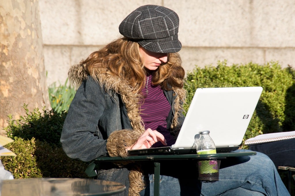 A woman looks at her computer in Bryant Park. 