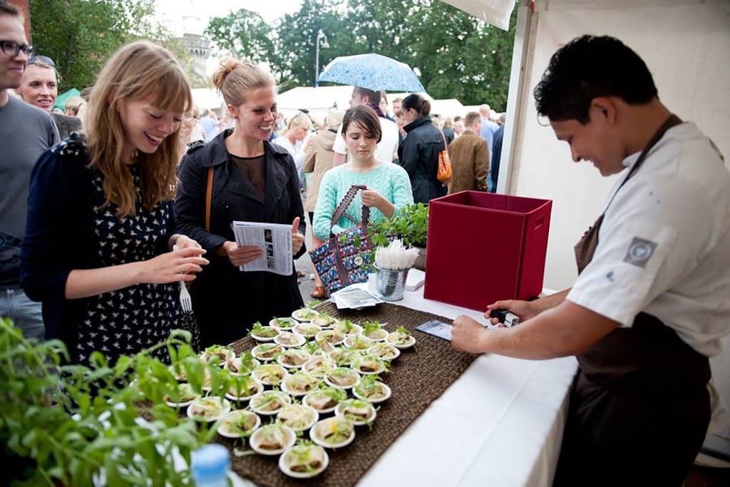 Visitors walk up to a chef's stand at the Copenhagen Cooking food festival. 