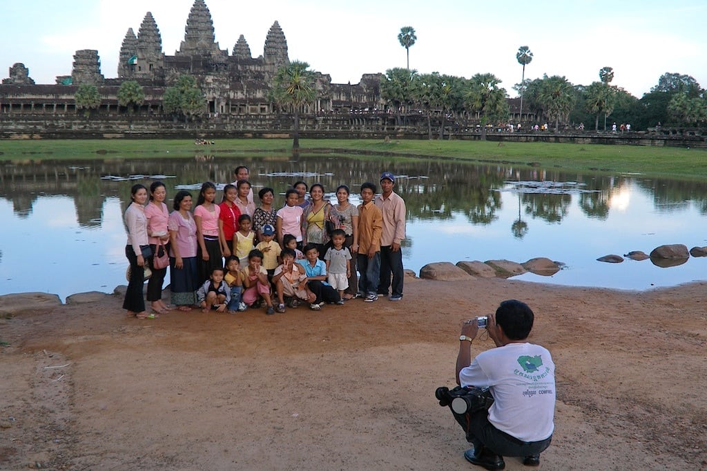 A family takes a photo in front of the temples in Angkor Wat, Cambodia. 