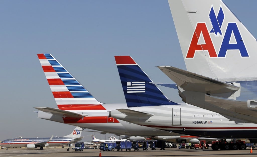 In this Thursday, Feb. 14, 2013 file photo, U.S. Airways and American Airlines planes are shown at gates at DFW International Airport in Grapevine, Texas. 