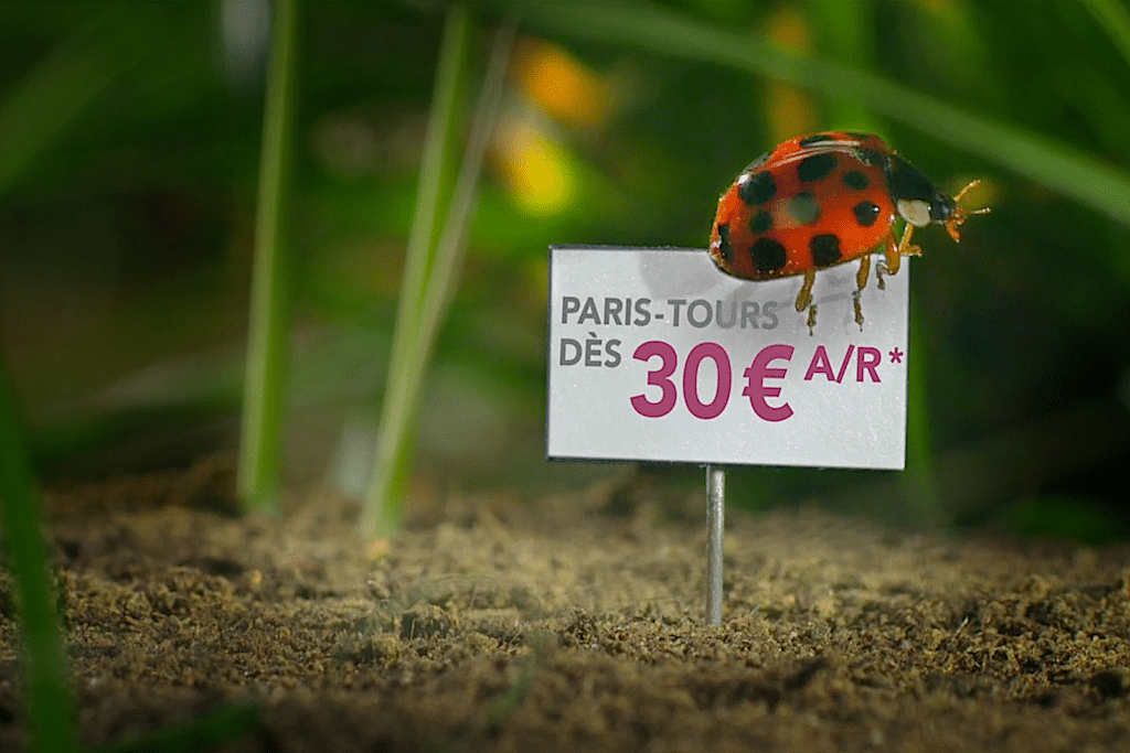 A ladybug crawls around a cage where SNCF uses tiny price tags to illustrate its low rates. 