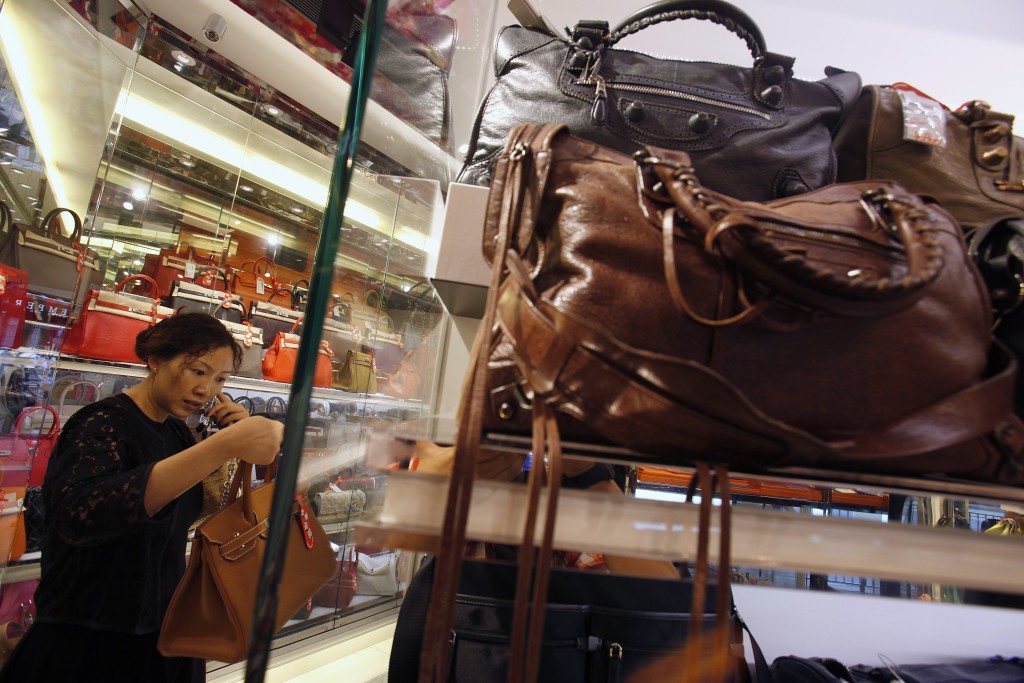 Luxury brands are chasing millennial buyers. A customer checks a luxury handbag at a Milan Station outlet in Hong Kong September 2, 2013. 