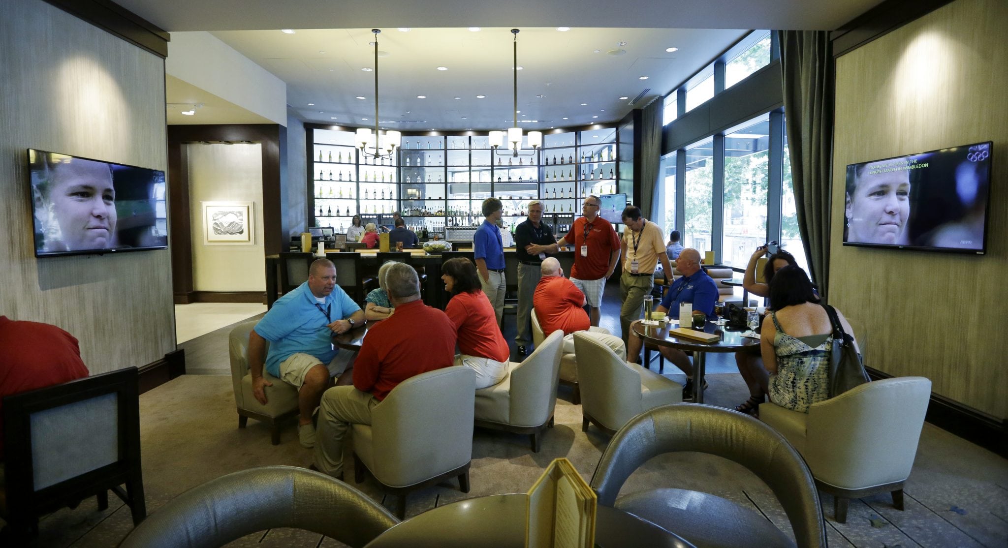 In this July 3, 2013, photo, guests socialize in the newly-redesigned bar area during "social hour" at a Sheraton hotel in Seattle. 