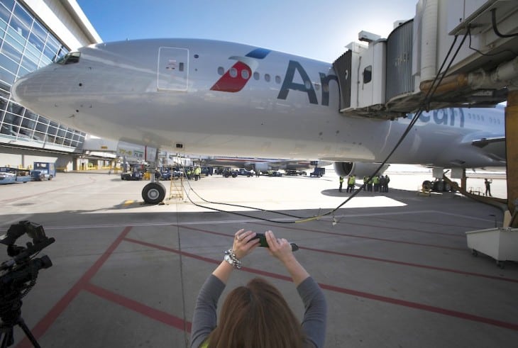 American Airlines Communications worker Andrea Hugely takes a photo of the new American Airlines Boeing 777-300ER at Terminal D at DFW Airport in Euless, Texas, January 31, 2013. 