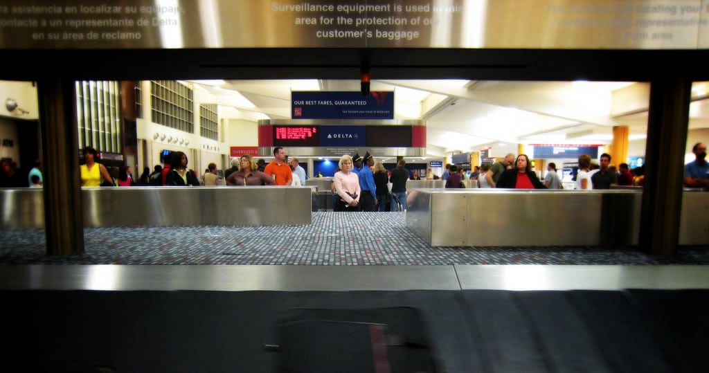 Most Spirit customers try to avoid checking and waiting for bags like these passengers at Atlanta-Hartsfield International Airport. 