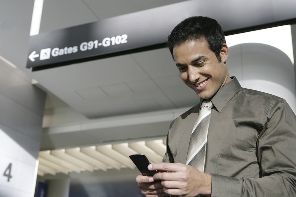 A businessman text messages in airport.