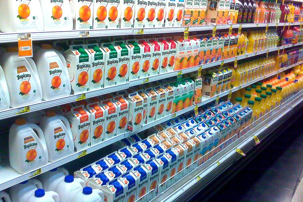 Orange juice cartons lined up in the grocery store. 