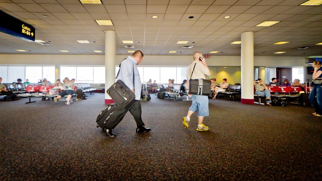 Two travelers walk through Charlotte Douglas International Airport. 