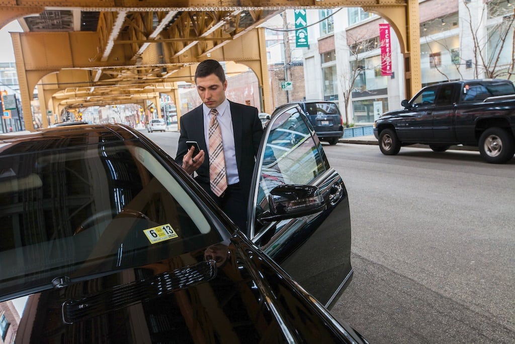 United Airlines is promoting Uber service in United's mobile apps. Pictured, limousine driver Florian Bucea checks his Uber service in Chicago, Illinois, on March 25, 2013. 