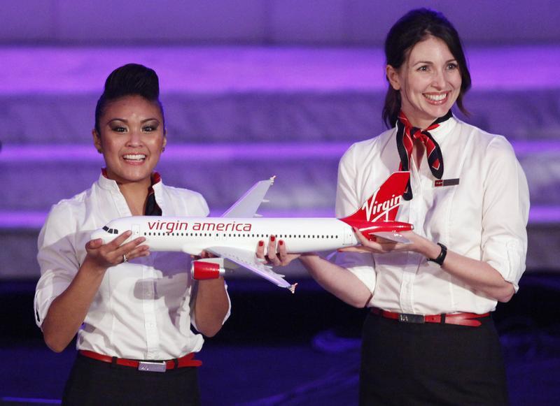 Virgin America flight attendants hold model of Virgin America Airbus A320 commercial aircraft in Los Angeles.