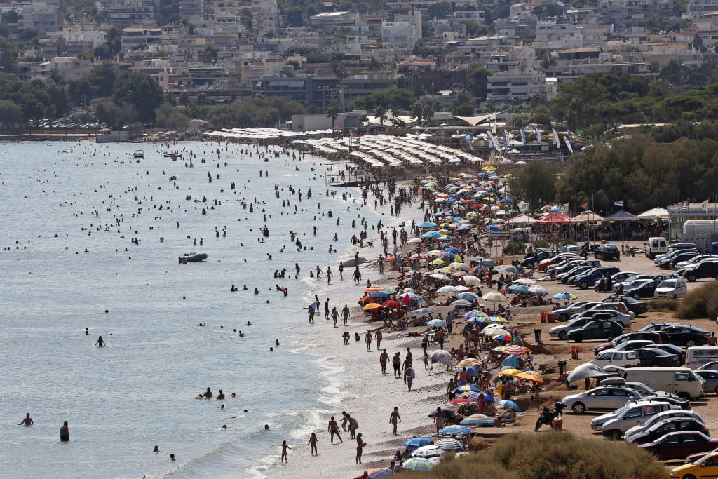 Tourists enjoy the hot weather at Vari beach, southeast of Athens. 