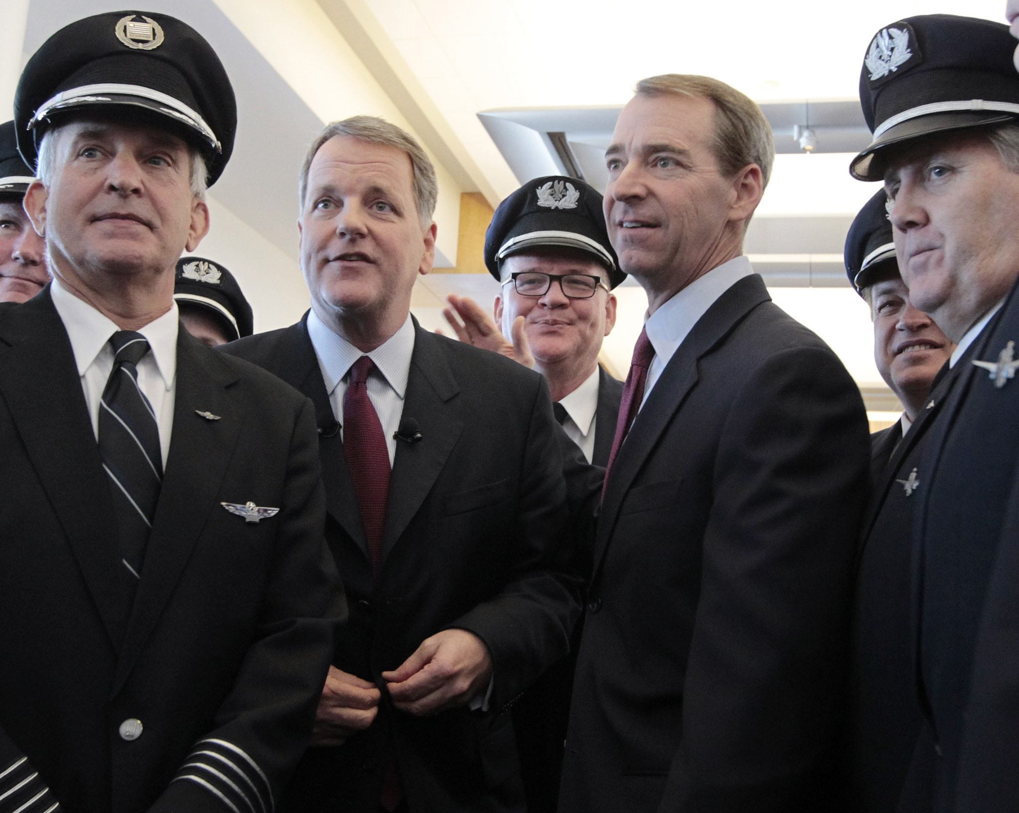 Pilots from both airlines gather for a photo with Doug Parker, left, then of U.S. Airways and Tom Horton of American Airlines after the announcement of the airlines' merger during a news conference at Dallas-Fort Worth International Airport, Thursday, February 14, 2013. 