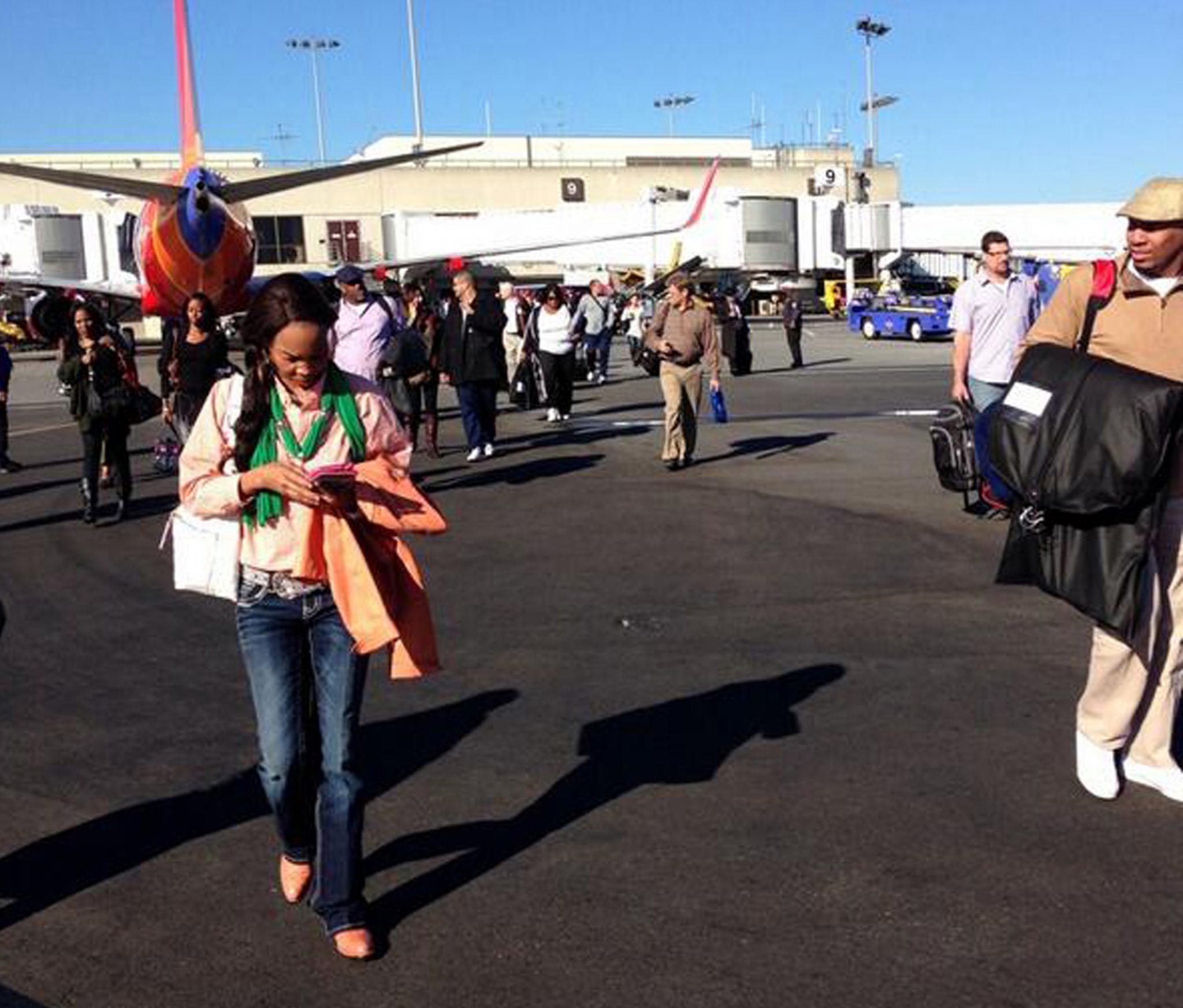 Airline passengers are evacuated to the tarmac at Los Angeles International Airport. 