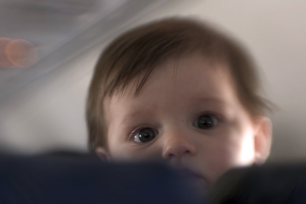 A baby pops his head over a plane seat on a flight to Port Aransas, Texas. 
