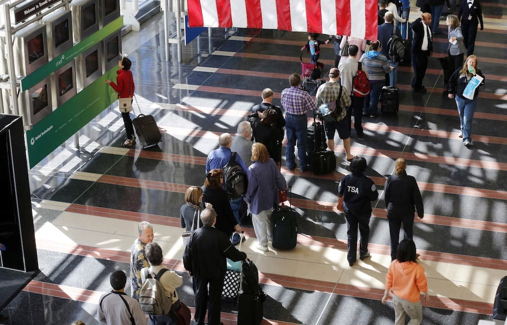 A line of passengers wait to enter the security checkpoint before boarding their aircraft at Reagan National Airport in Washington, April 25, 2013. 
