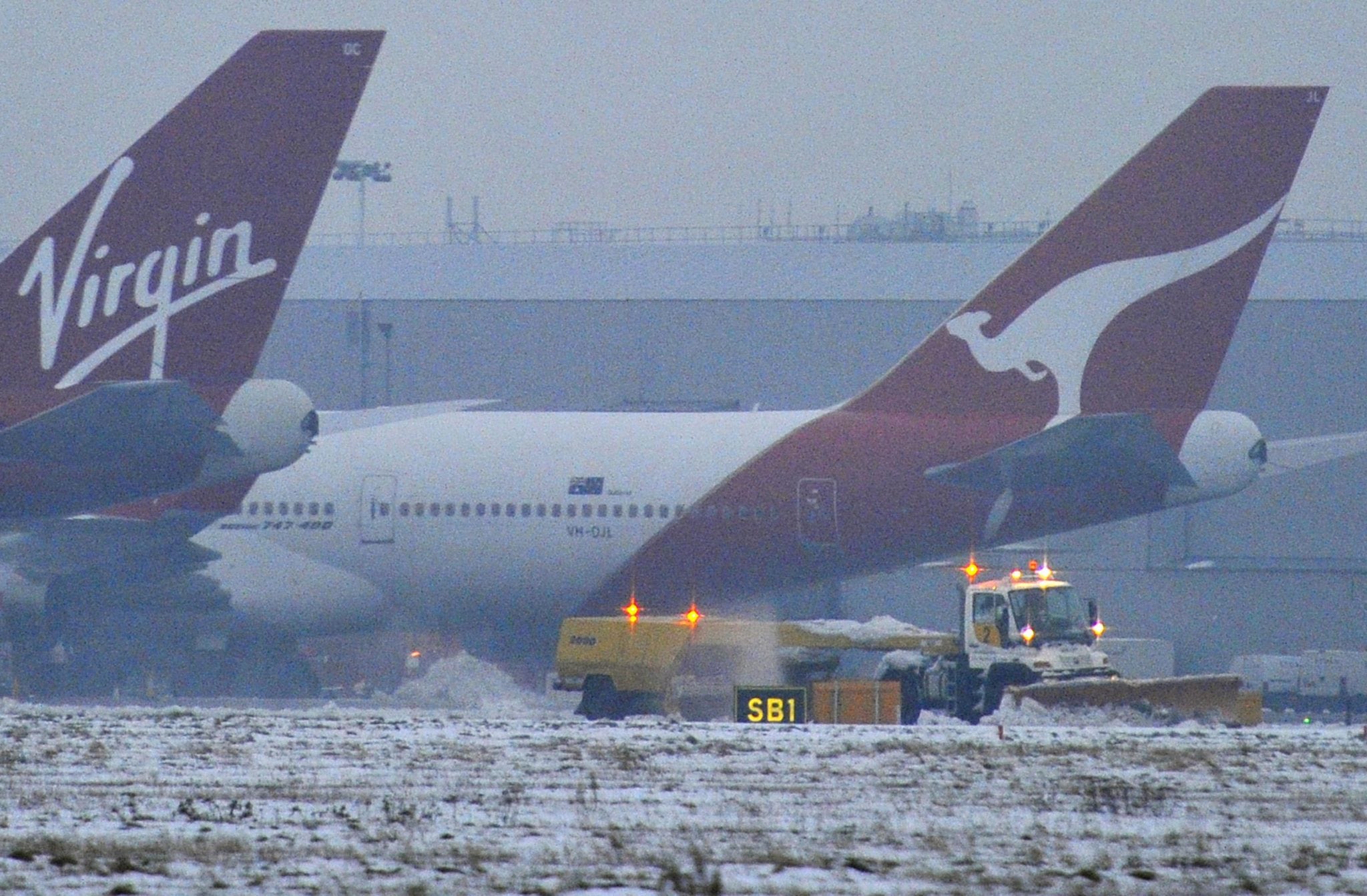 File photo of snow being cleared near Qantas and Virgin planes at Heathrow airport in west London. 